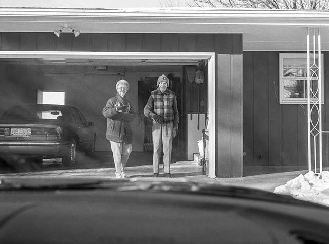 foto in bianco e nero di uomo e donna anziani davanti a un garage