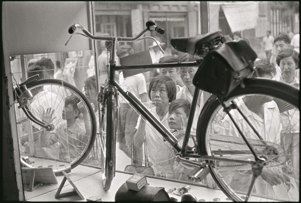 asiatici che guardano una bicicletta in vetrina