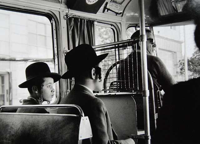 due ragazzi ebrei con cappello seduti su un autobus dietro a conducente con occhiali scuri