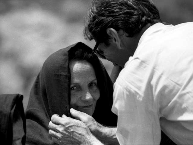 fotografia in bianco e nero di Pier Paolo Pasolini che aggiusta il velo ad una comparsa sul set