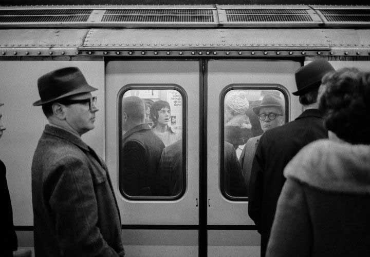 persone davanti a carrozza della metro affollata che aspettano di entrare