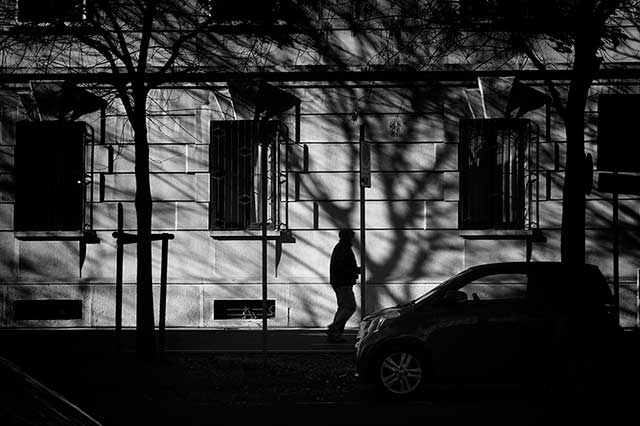 uomo in ombra che cammina per la strada