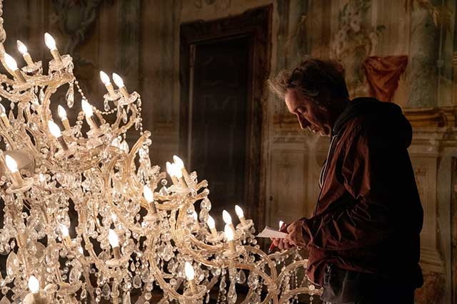 Paolo Sorrentino sul set che sistema lampadario a gocce