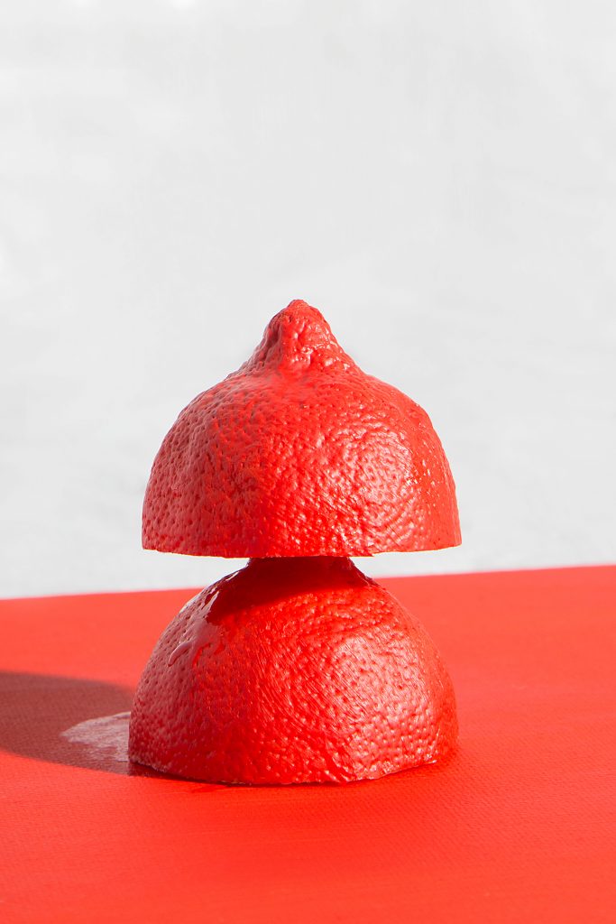 limone rosso tagliato a metà su piano rosso