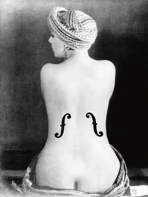 fotografia in bianco e nero di una donna nuda con turbante di spalle con dipinte sulla schiena due effe della cassa di violino