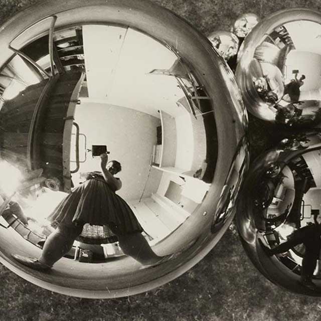 la fotografa Marianne Brandt con la macchina fotografica riflessa in 3 sfere specchiate