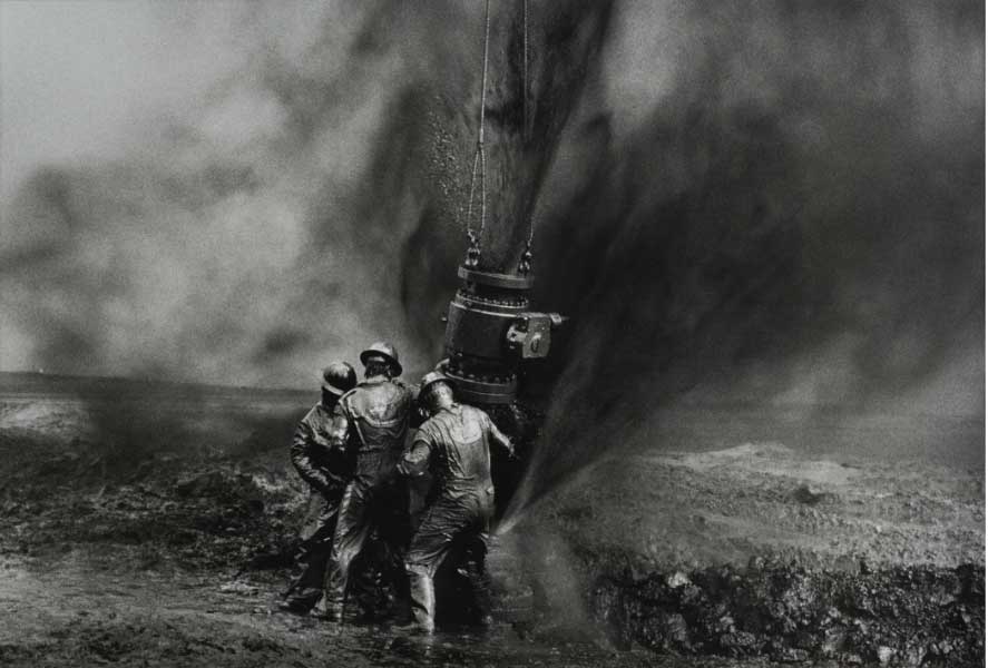 tre uomini che estraggono il petrolio con una pompa