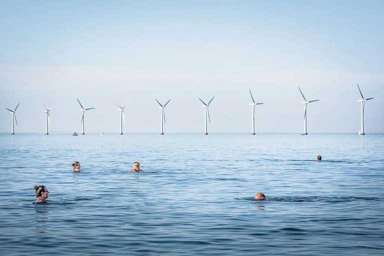 cinque persone che fanno il bagno in mare con delle eliche sullo sfondo