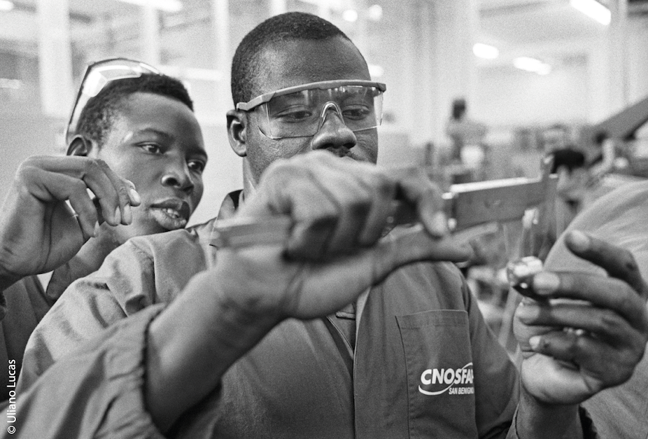 fotografia in bianco e nero di due ragazzi africani che lavorano in una fabbrica