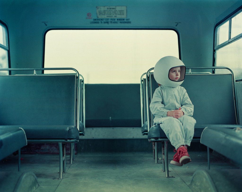 bambino vestito da astronauta seduto in autobus vuoto
