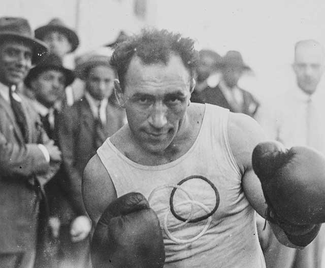il pugile Bruno Frattini con canottiera con cerchi olimpici e guantoni da boxe