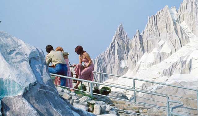 Luigi Ghirri Reggio Emilia un uomo e due donne di spalle seduti su una ringhiera che guardano montagne innevate dell'Italia in miniatura