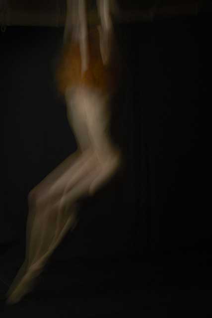 immagine mossa su sfondo nero di corpo di donna con le braccia alzateco