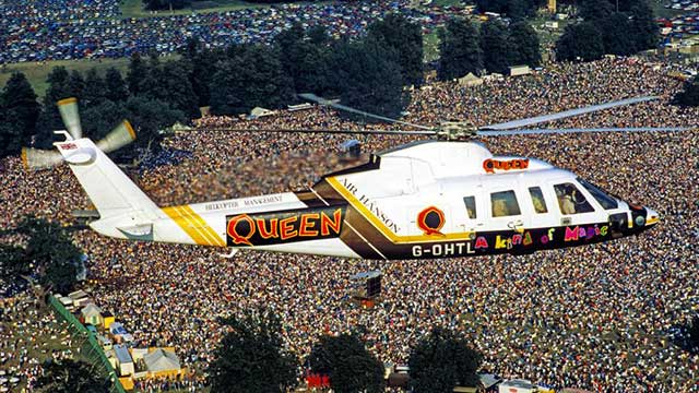 elicottero che trasporta i Queen sorvola il parco di Londra pieno di gente dove avverrà il concerto