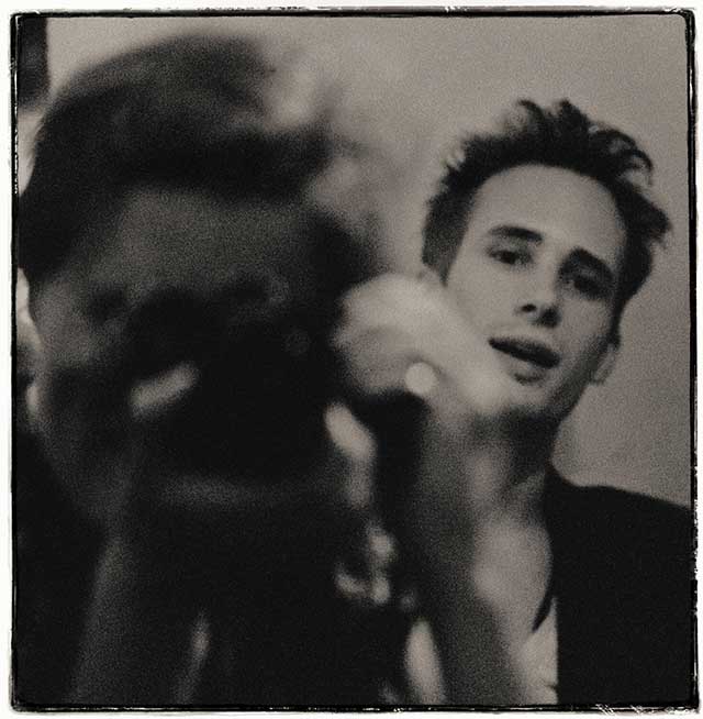 la fotografa merri cyr davanti allo specchio con la macchina fotografica con alle sue spalle il musicista jeff buckley riflesso nello specchio