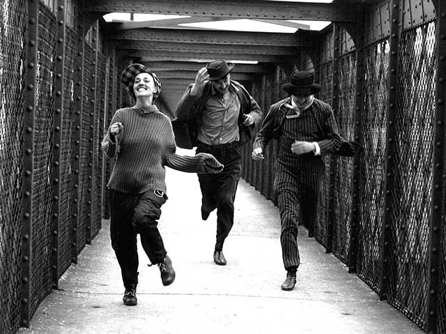 tre giovani che attraversano di corsa un ponte ridendo