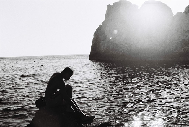 uomo in controluce seduto su uno scoglio davanti al mare festival di fotografia di Capri