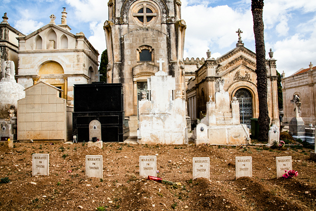 Max Hirzel cimitero con tante cappelle e tombe e sulla terra sei piccole lapidi con su scritto migrante e dei numeri
