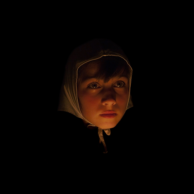 Aldo Sardoni fotografia a colori con luce molto fioca che illumina primo piano di bambina con fazzoletto bianco in testa