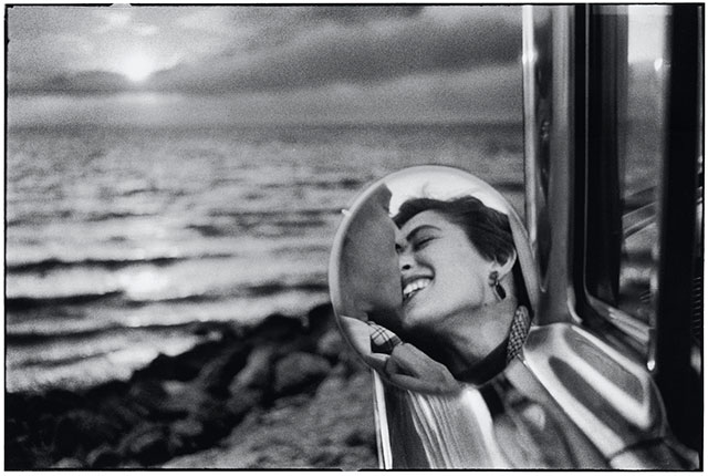 Elliott Erwitt Photographs foto in bianco e nero con specchietto di macchina che ritrae un uomo e una donna che stanno per baciarsi davanti al mare
