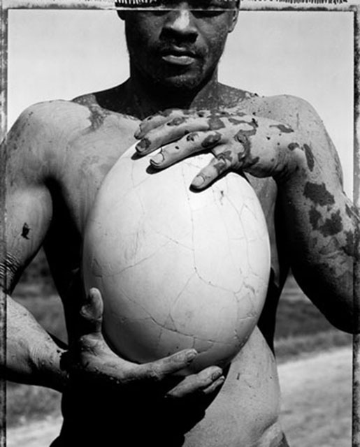 Gian Paolo Barbieri Fuori dal tempo immagine in bianco e nero ravvicinata di ragazzo su una spiaggia del Madacascarche tiene in mano davanti a sè un enorme uovo bianco