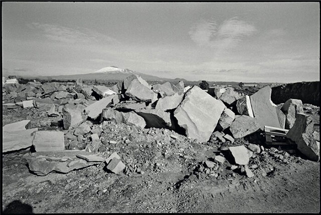Ettore Sottsass Catania Mia! foto in bianco e nero di grossi massi accatastati con sullo sfondo l'Etna innevato