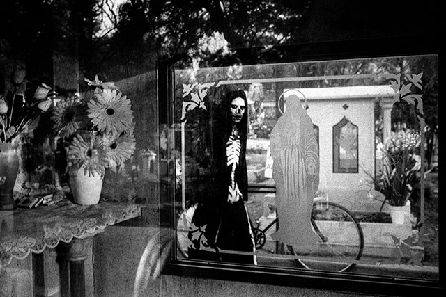 Giuseppe Cardoni Roma foto in bianco e nero persona mascherata da scheletro si riflette nello specchio di una vetrina