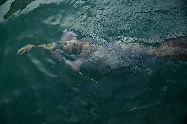 monica marioni donna adagiata sott'acqua a pancia sotto come se dormisse con il viso appoggiato dul braccio e le mani congiuntea