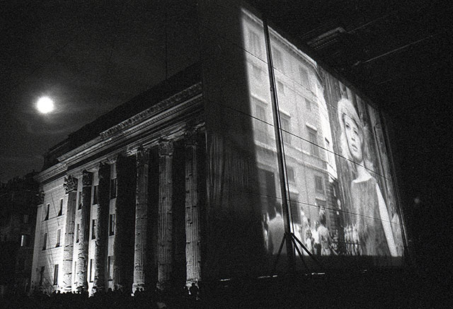 Paolo Grana Roma foto in bianco e nero di immagine di Monica Vitti proiettata a Roma a Piazza di Pietra