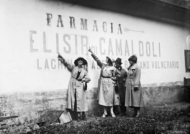 Archivi Alinari Arezzo foto in bianco e nero di donne che indicano pubblicità di farmacia scritta su un muro