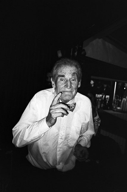 Federico Arcangeli Rimini foto in bianco e nero di uomo anziano con camicia bianca e papillon con il dito alzato e sguardo sorridente
