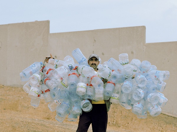 Photography Grant Bologna foto a colori di uomo che tiene intorno al corpo tante bottiglie di plastica legate fra loro