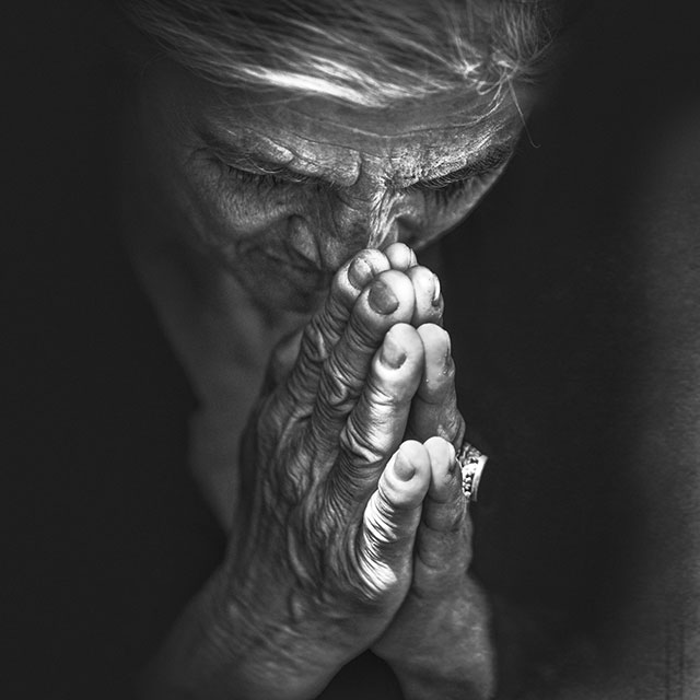 Lee Jeffries Milano foto in bianco e nero di donna con gli occhi bassi e le mani conserte sul viso