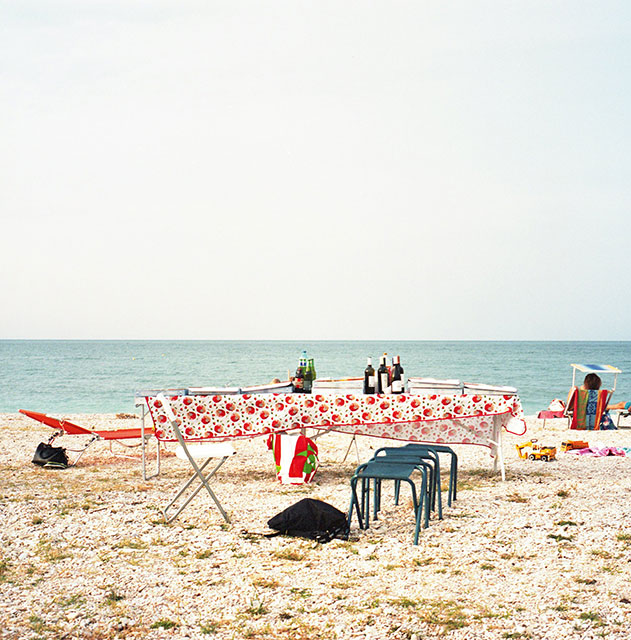 Riccardo Fregoso Gorizia foto a colori di spiaggia con tavolo apparecchiato con tovaglia e bottiglie