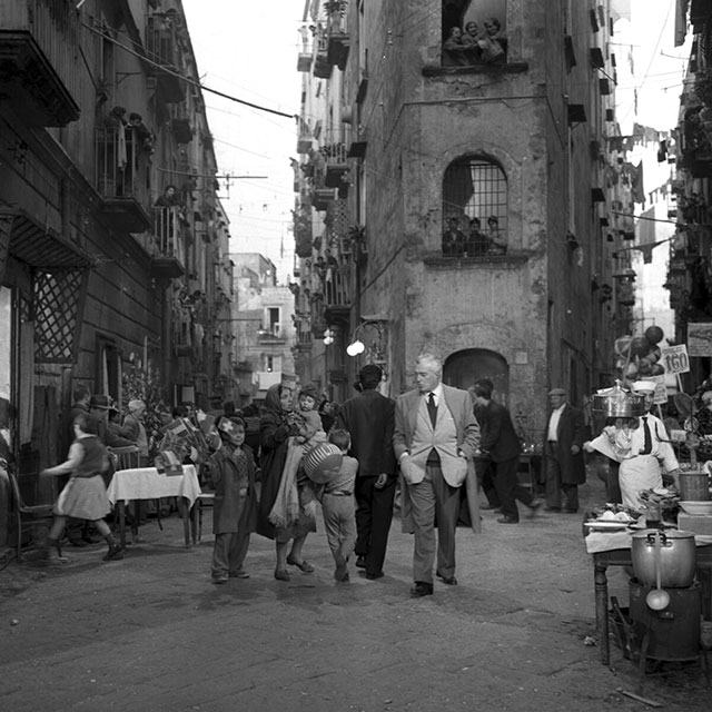 Paesaggi del cinema italiano Cesena foto in bianco enero del regista Vittorio De Sica che cammina per la via affollata di gente