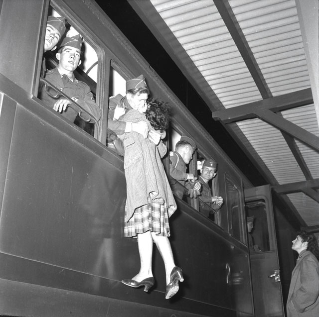 Ugo Borsatti Trieste foto in bianco e nero militare affacciato alla finestra del treno bacia ragazza alzandola da terra