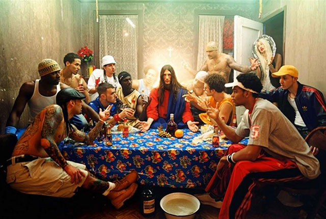 David LaChapelle Brescia foto a colori di ricostruzione dell'ultima cena con Gesù con tunica e capelli lunghi e gli apostoli vestiti moderni con tua e scarpe da ginnastica