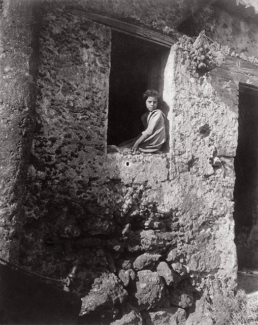 Giovanni Verga Seriate foto in bianco e nero di bambina seduta alla finestra di una casa in pietra