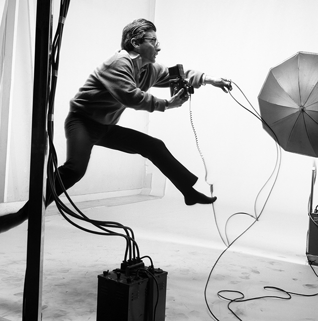 Jacques Henri Lartigue Alba foto in bianco e nero di Avedon nel suo studio fotografico che salta con la macchina fotografica in mano
