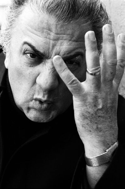 Fellini Mamiano di Traversetolo ritratto in bianco e nero del regista Federico Fellini mentre fa una smorfia con la mano aperta davanti al viso