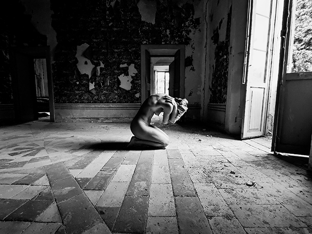 Ascosi lasciti Napoli foto in bianco e nero di donna nuda inginocchiata in una stanza con la testa bassa e le braccia intorno al collo