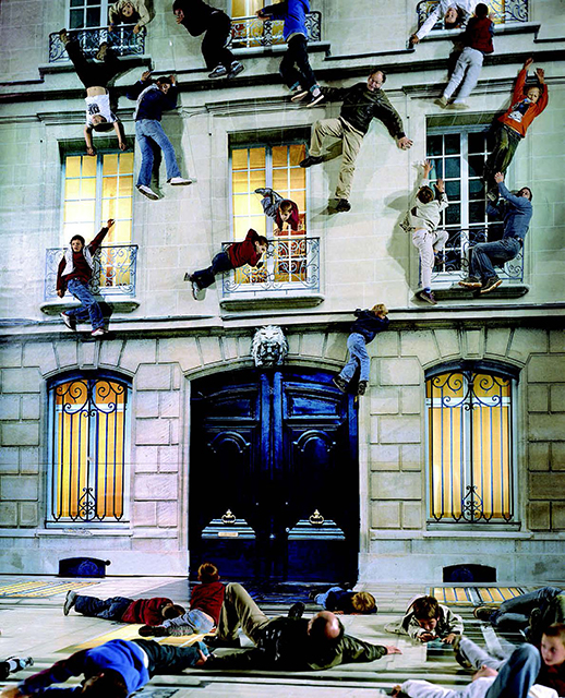 Leandro Elrich Milano foto a colori di uomini donne ebambini appesi alle finestre di una palazzina e sdraiati per la strada