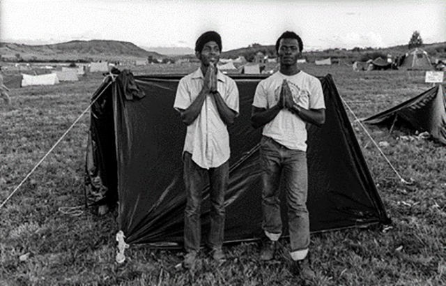 Arthur Nager Roma foto in bianco e nero di due ragazzi di colore con le mani giunte davanti ad una tenda nera in un prato