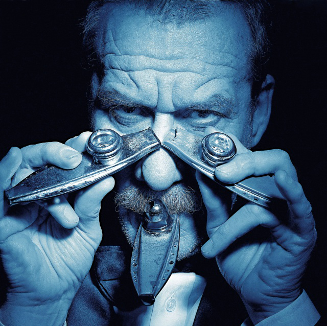 Guido Harari Mogoro foto virata blu del cantante Paolo conte che tiene in mano appogiati al naso due kazoo e uno in bocca