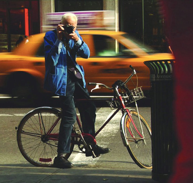 Bill Cunningham New York foto a colori del fotografo Bill Cunnigham in bicicletta per le strade di New York