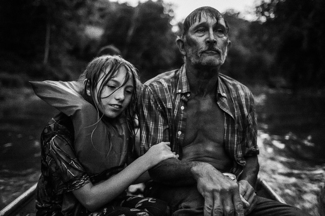 Festival della fotografia etica Lodi foto in bianco enero di uomo e bambina bagnati seduti in canoa su fiume