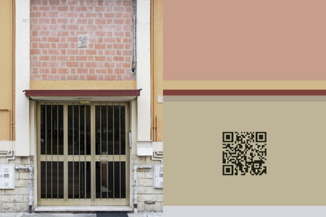 Abitare lo sguardo Piacenza foto a colori di portone di palazzo con codice a barre sul muro