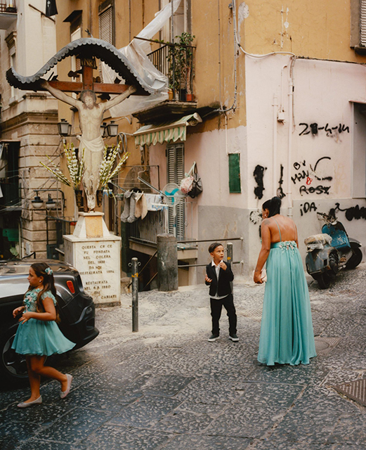 Festival di fotografia Capri foto a colri di donna con abito lungo celeste che parla con bambino in strada