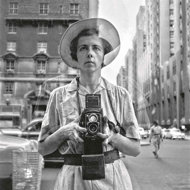 Vivian Maier Bologna foto in bianco e nero della fotografa Vivian Maier che si ritrae con la macchina fotografica davanti ad una vetrina di un negozio