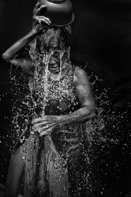 Yeast Photo Festival 2023 Matino foto in bianco e nero di donna che si versa ciotola d'acqua in testa